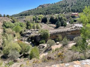 a bridge over a river with a mountain in the background at Halona Casa Rural in Bullas +13 photos