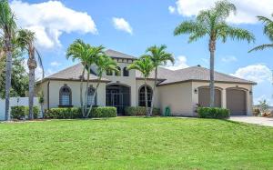 a house with palm trees in front of a yard at Surfside in Cape Coral