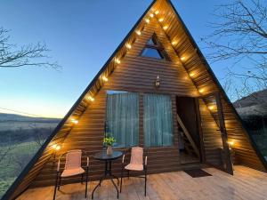 a tiny house with a triangular roof with a table and chairs at Altimo კოტეჯი ალტიმო in Norio