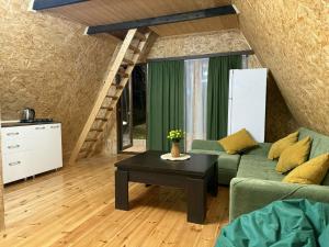 a living room with a green couch and a table at Altimo კოტეჯი ალტიმო in Norio