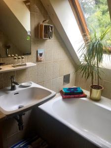 Villa Pdorf في بيرشتولدسدورف: حمام مع حوض وحوض استحمام ونافذة