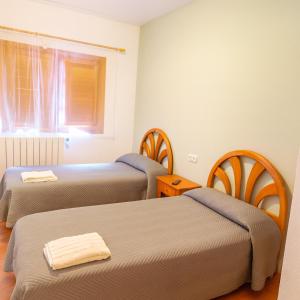 una stanza con due letti e una finestra di Pensión San Cristóbal by Bossh! Hotels a Cuenca