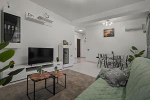 a living room with a couch and a flat screen tv at Apartament Militari Residence in Dudu