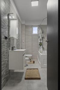 a bathroom with a sink and a toilet and a tub at Apartament Militari Residence in Dudu