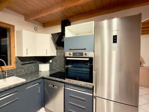 eine Küche mit einem Kühlschrank aus Edelstahl und einer Spüle in der Unterkunft CAL QuEROL UR casa amb xemeneia i billar in Ur + 7 Fotos