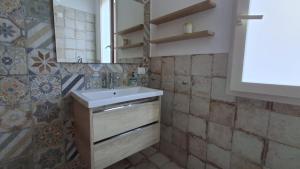 un bagno con lavandino e specchio di La Finestra su Mothia a Marsala