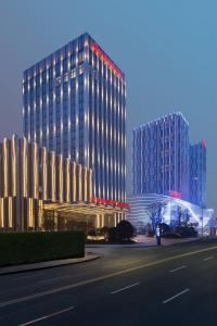 a tall building with lights on it next to a street at Wanda Realm Jingzhou in Jingzhou