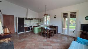 una cucina con un tavolo e alcune sedie e una cucina con un piano del tavolo di La Finestra su Mothia a Marsala Altre 34 foto