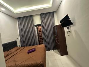 una camera da letto con un cuscino viola di Kubu Gandi Homestay a Denpasar