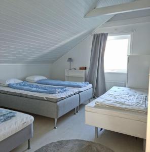 Cosy rural apartment close to Nösund SE09122 في Strand: غرفة نوم بها سريرين ونافذة