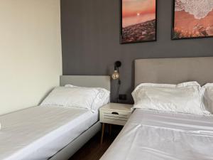 two beds sitting next to each other in a bedroom at Bilocale luminoso ed elegante-Parcheggio gratuito in La Spezia