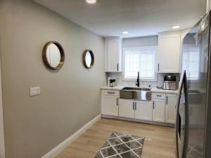 Una cocina con gabinetes blancos y un fregadero y un espejo. en 8354, Adams unit B, en Lemon Grove