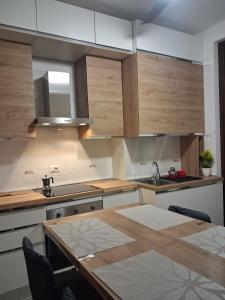a kitchen with wooden cabinets and a table and a sink at Bilocale comodamente collegato con centro Milano in Garbagnate Milanese