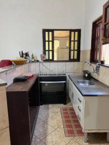 een keuken met een spoelbak en een fornuis bij Quarto privativo em casa de praia próxima a cachoeira in Bertioga +26 foto's