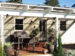 a screened in porch with a piano on a deck at Jamieson Cottage in Warrnambool