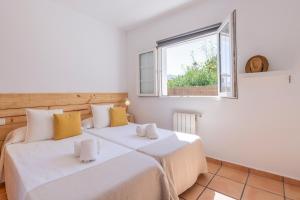 Casa Lucia a 500 m de la playa - Formentera Natural في لا سافينا: سريرين في غرفة بها نافذة