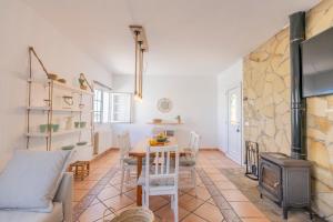 Casa Lucia a 500 m de la playa - Formentera Natural في لا سافينا: غرفة معيشة مع طاولة وموقد خشبي