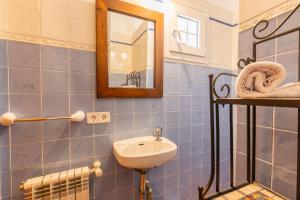 Casa Lucia a 500 m de la playa - Formentera Natural في لا سافينا: حمام من البلاط الأزرق مع حوض ومرآة +21 صورة