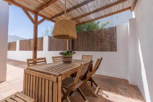 Casa Lucia a 500 m de la playa - Formentera Natural في لا سافينا: غرفة طعام مع طاولة وكراسي خشبية