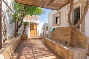 Casa Lucia a 500 m de la playa - Formentera Natural في لا سافينا: ممشى يؤدي إلى منزل مع باب خشبي