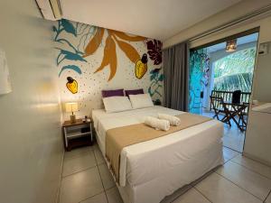 a bedroom with a bed with a pineapple mural on the wall at Pousada Unaí in Porto De Galinhas