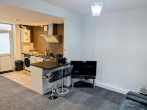 a living room with a kitchen with a counter top at Modern One Bedroom Flat With Garden in Cardiff