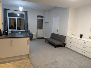 a living room with a couch and a chair at Modern One Bedroom Flat With Garden in Cardiff