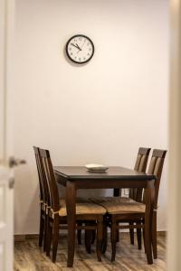 a dining room table with chairs and a clock on the wall at Apartment Center in Kolašin +8 photos
