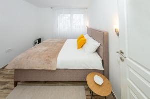 a small bedroom with a bed with a yellow pillow at Apartment Center in Kolašin