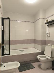 a bathroom with a tub and a toilet and a sink at Luxury Monte 65 in Tomelloso +38 photos