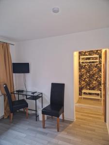 ein Wohnzimmer mit einem Tisch, Stühlen und einem Gemälde in der Unterkunft Hotel Haus Niggemann in Hattingen