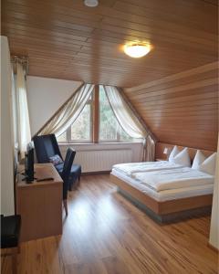 ein Schlafzimmer mit einem Bett, einem Schreibtisch und einem Stuhl in der Unterkunft Hotel Haus Niggemann in Hattingen