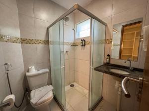a bathroom with a shower and a toilet and a sink at Pousada Unaí in Porto De Galinhas