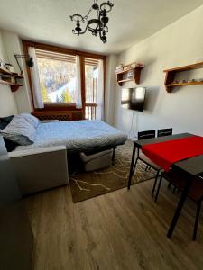 a bedroom with a bed and a table and a desk at da Robi appartamento fronte piste in Borgata Sestriere