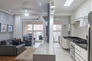 una cucina e un soggiorno con un divano e un tavolo di Brisa do Mar - Varanda/2 qtos/Est/Ar a Campo Grande