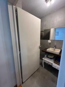 een badkamer met een witte deur en een wastafel bij Vilella Live in Buenos Aires