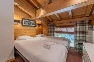 l'Ours Bleu C21 - Ski In Ski Out - Happy Rentals في فالورسين: سريرين في غرفة ذات جدران خشبية