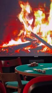 a poker table in front of a screen with fire at Villa Summer Wind - Palm Beach Agathois in Le Grau-dʼAgde