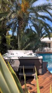 a hot tub sitting on a deck next to a pool at Villa Summer Wind - Palm Beach Agathois in Le Grau-dʼAgde