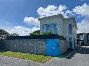 a white house with a brick retaining wall at Carters Beach Retreat in Carters Beach +2 photos