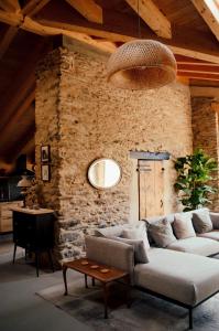 a living room with a couch and a stone wall at Espectacular Chalet de Montaña Pirineos, Burg in Burg