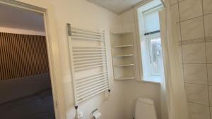 a white bathroom with a toilet and a window at Apartment in the heart of Esbjerg Center in Esbjerg +10 photos