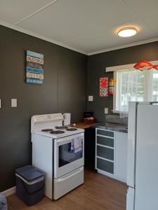 a kitchen with a stove and a refrigerator at Waitangi Beach Unit B in Paihia