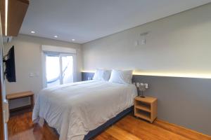 a bedroom with a large white bed and a window at Pousada Ilha Faceira in Florianópolis +111 photos