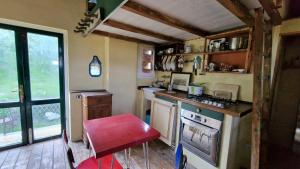 a small kitchen with a stove and a red stool at fienile di frida in Lucca