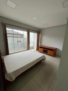 een slaapkamer met een bed en een groot raam bij Casa da Vivi in Socorro