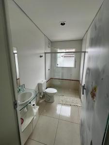 een witte badkamer met een toilet en een wastafel bij Casa da Vivi in Socorro +30 foto's