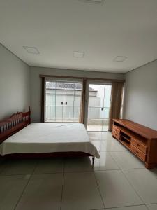 een slaapkamer met een groot bed en een houten tafel bij Casa da Vivi in Socorro