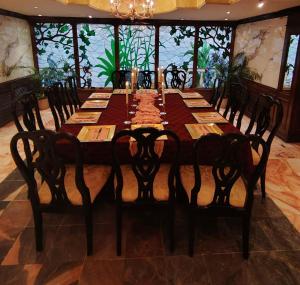 Un comedor con una mesa larga con sillas. en Hotel Virrey, en Reynosa