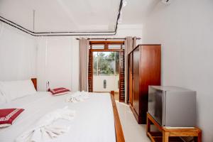 a bedroom with a bed and a television at Villa Tanzanite Hikkaduwa in Hikkaduwa